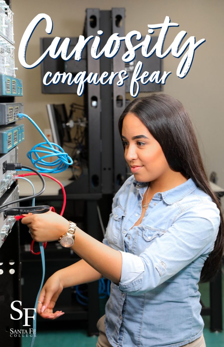 Young woman with long black hair and light brown skin is unplugging cables from a network server.